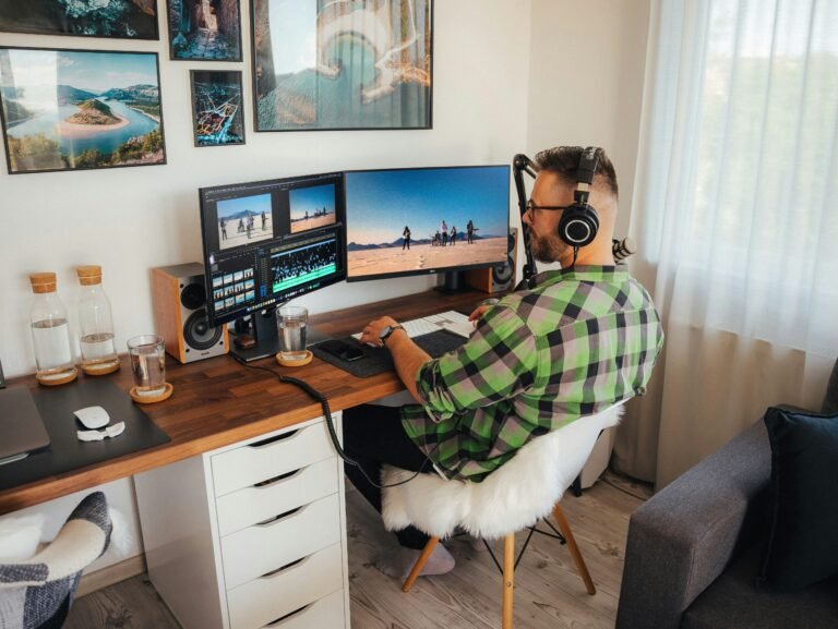 a person sitting at a desk with a computer and headphones on